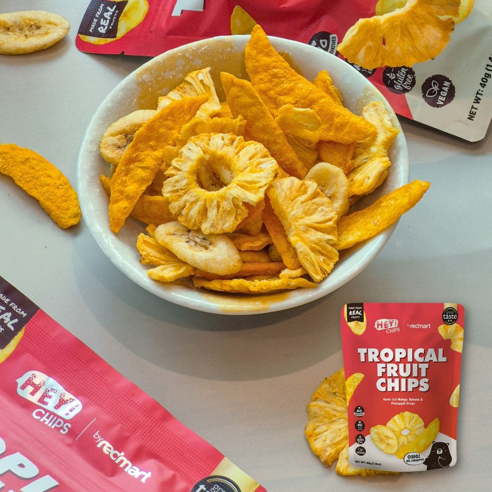 Hey! Chips tropical fruits in a bowl with packaging on a white surface.